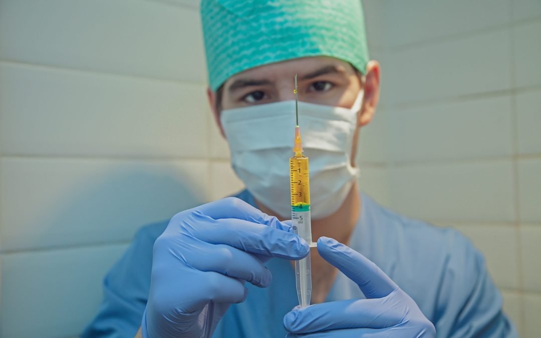 person in blue knit cap holding clear glass tube